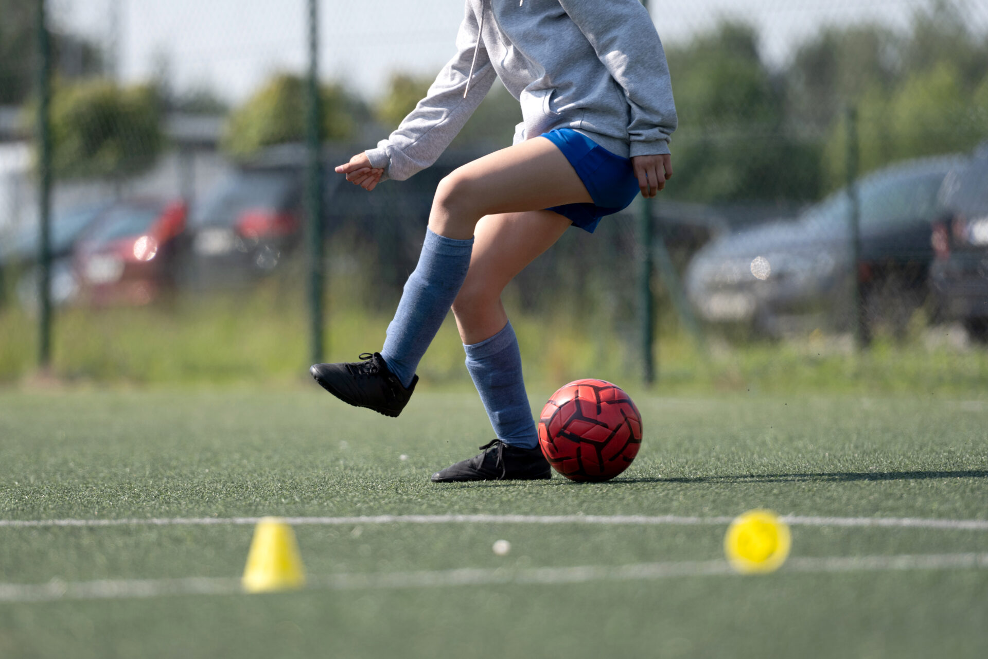 Girl Skillfully Dribbles Ball Between Flip Cups During Football Practice