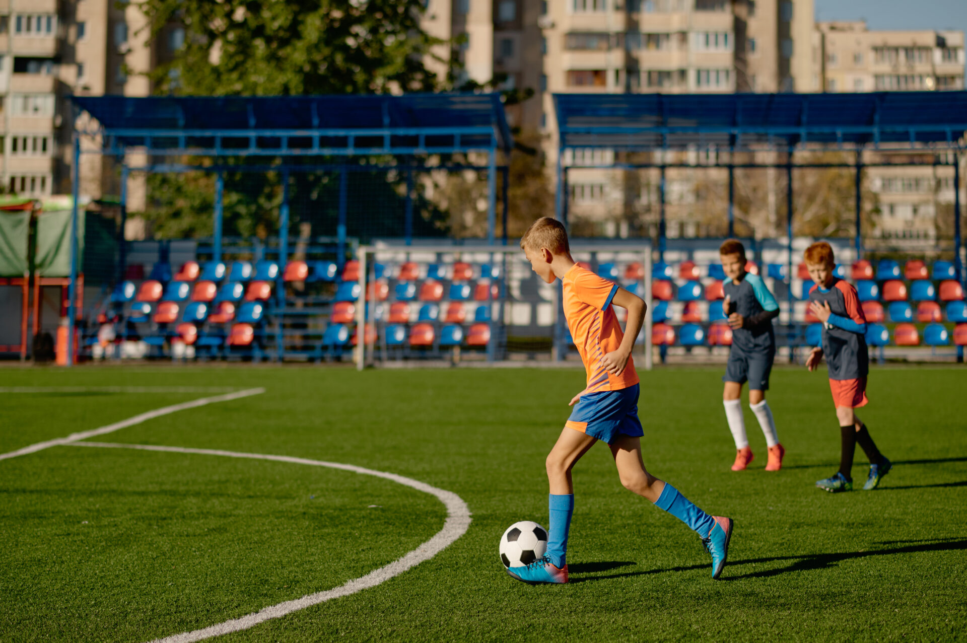 Young boys playing football match at training camp for kids